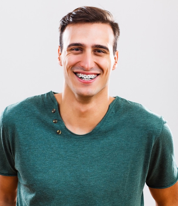 Smiling man in teal shirt against white background, professional headshot for orthodontics practice.