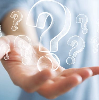 Hand holding glowing question marks representing orthodontic inquiries and patient concerns.
